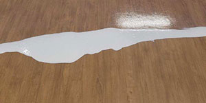 application of coating to sheet vinyl floor